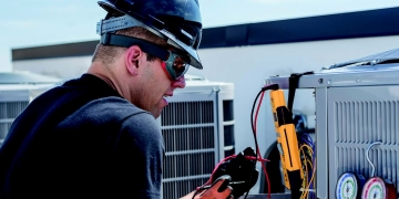 Expert Walker J Walker worker taking readings on a commercial HVAC unit